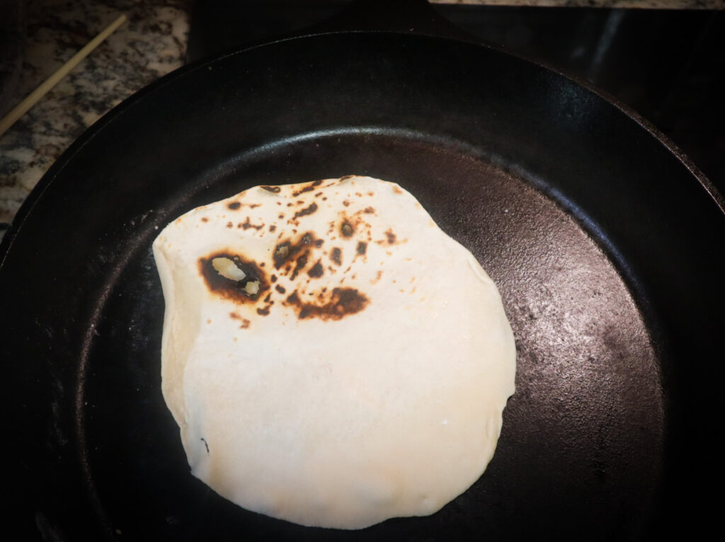 tortillas cooking in cast iron pan