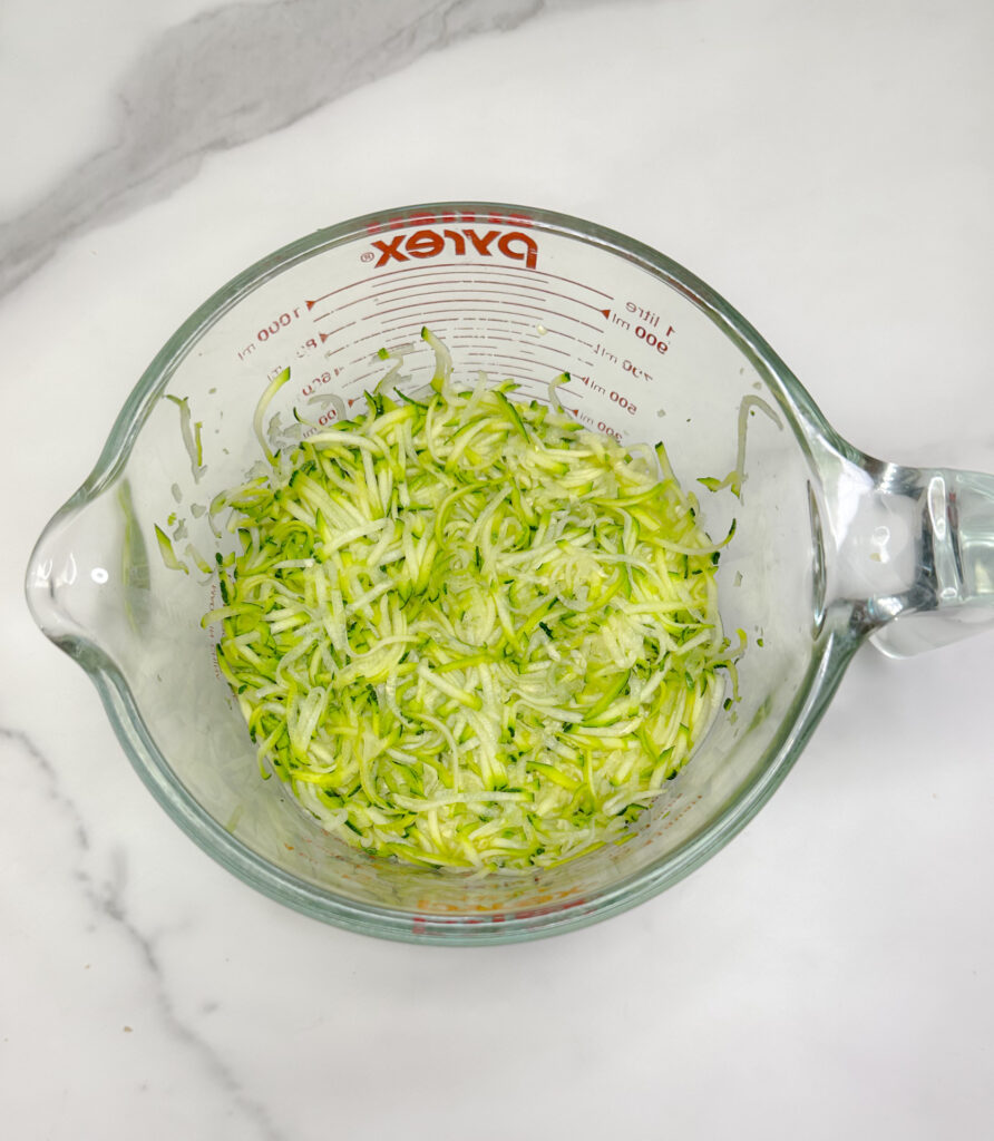 zucchini grated in a measuring cup