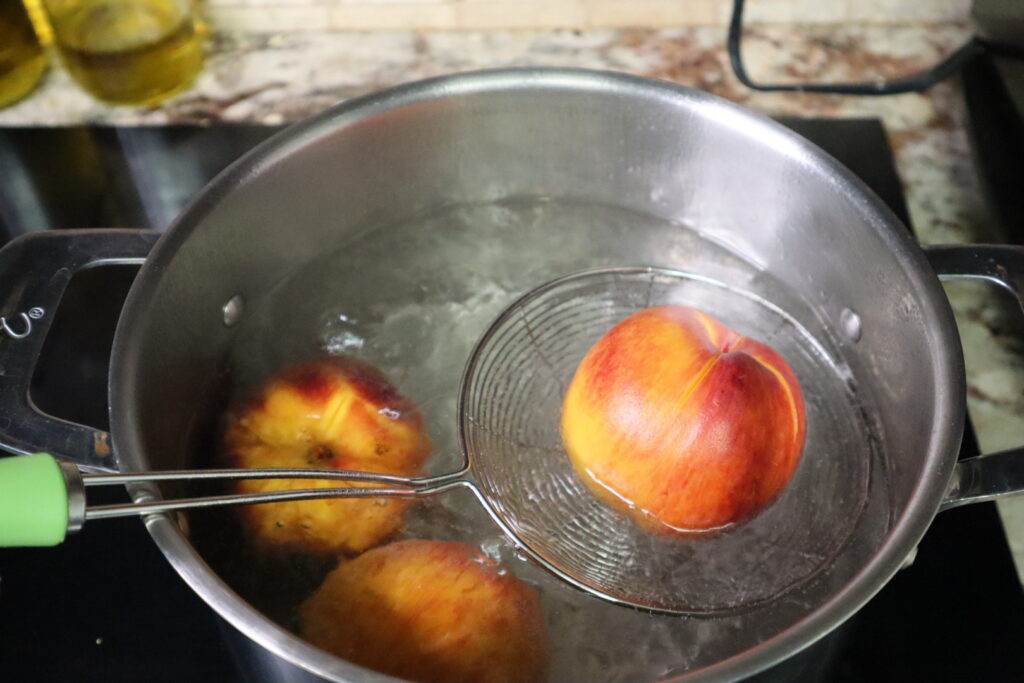 fresh peaches being blanched for peach cobbler